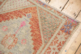 Distressed Oushak rug close-up revealing stepped orange and pink geometric motifs with soft pile wear.