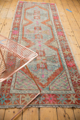Distressed Oushak runner, central stepped medallion with soft rust, hot pink, and light blue.