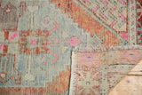 Distressed Oushak rug runner pile with wear, fringed edge, and visible hand-knotted reverse.
