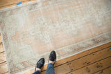 Faded vintage Oushak runner corner with barber pole border and geometric spandrel.