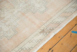Close-up of vintage Oushak runner, highlighting textured pile, worn knot heads, and pale sand border.