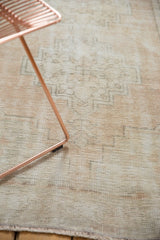 Distressed vintage Oushak runner texture, showing exposed foundation and muted geometric pattern.