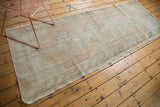 Distressed Oushak rug runner edge, showing intact selvage, barber pole border, and geometric medallions.
