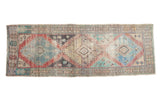Distressed Vintage Oushak runner rug with geometric medallions in faded blue, saffron, ivory.
