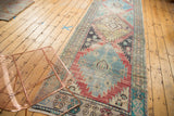 Distressed Oushak runner, worn texture with geometric patterns in sky blue, red, saffron.