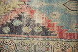Distressed Oushak runner detail highlighting geometric motifs, worn pile, and sky blue, red, ivory tones.