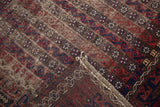 Antique Belouch rug showing woven channels of water, blossoms, and the patterned reverse side.