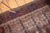 Antique Belouch rug field with etched brown and navy pile and saffron yellow blossomed motifs.