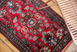 Vintage Hamadan rug corner showing Lilihan-like bursting floral arrangements and a navy border.