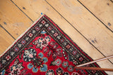Vintage Hamadan rug corner with cherry red Lilihan-like floral pattern and secured fringe.