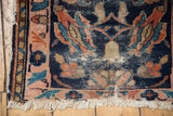 Antique Lilihan rug corner with tattered fringe, blush rose border, and worn indigo field.