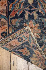Antique Lilihan rug corner showing worn indigo field, pale blush border, and hard tattered fringe.