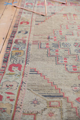 Distressed ivory field showing geometric patterns in faded cinnabar red and slate blue.