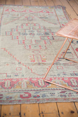 Distressed Oushak rug runner border in muted cinnabar, dusty ivory, and faint fringe.