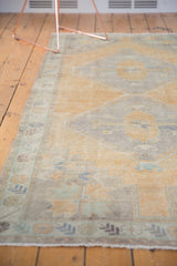 Textured pale mint green border and faded saffron field of the distressed Oushak runner.