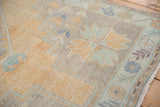 Distressed Oushak rug pile close-up, showing even wear with saffron, silver, and mint green.