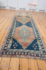Distressed low pile fringe and floral border of the vintage Oushak runner, blush and blue.