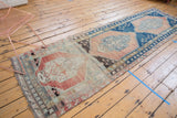 Distressed blush, sky blue, and brown Oushak runner with triple elongated medallions.