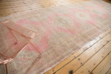 Distressed pink and ivory vintage Sparta rug runner showing worn pile and intact selvage.