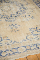 Distressed vintage Oushak carpet with faded denim blue blossomed floral patterns.