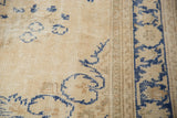 Distressed Turkish Oushak rug detail: denim indigo blue patterns, narrow border, and worn beige pile.
