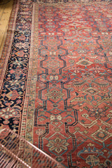 Vintage Heriz carpet's unusual cloud band motif, oversized floral, Laleh Abassi borders, visible wear.