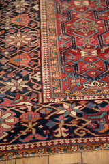 Vintage Heriz carpet with Laleh Abassi and starburst motifs in cherry red, navy, pale blue.