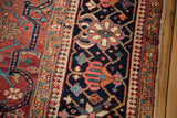 Oversized floral design in dark blue main border of vintage Heriz carpet.