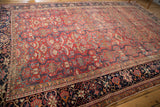 Heriz carpet detail: cherry red field with cloud bands, oversized floral border, Laleh Abassi motif.