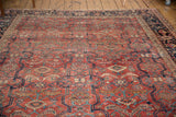 Vintage Heriz rug detail: cherry red field with running channel, cloud band, and samovar motifs.