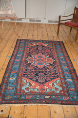 Navy field, blush quatrefoil medallion, aqua blue spandrel, and Herati motif on vintage Dargezine rug.