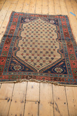 Antique Kurdish Hamadan rug corner featuring oversized navy floral spandrel, ivory outline, and tattered end.