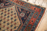 Antique Kurdish Hamadan rug corner: navy floral spandrel, camel lattice field, even wear.