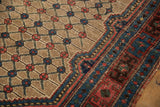 Detail of antique Kurdish Hamadan rug showing worn camel lattice field and blue border.