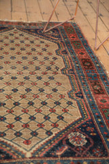 Antique Kurdish Hamadan rug corner, ivory-outlined floral spandrel, camel lattice, tattered edge.