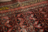 Antique Malayer rug's sharp serrated leaf pattern, worn texture, red and charcoal hues.