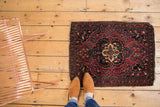 Antique Farahan Sarouk rug with red, navy floral field and visible tatter to ends.
