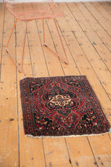 Antique Farahan Sarouk rug corner, cherry red and navy floral field, intricate border, aged fringe.