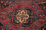 Antique Persian rug's intricate floral bouquets and scalloped medallion in ruby and sapphire tones.
