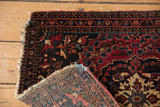 Tattered edges, floral pile, and woven foundation of an antique Farahan Sarouk rug.