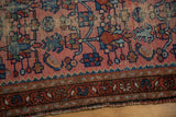 Vintage Lilihan rug's ornate multi-band border and stylized dusty rose field, with visible wear.