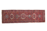 Vintage Karaja runner, cherry red field with geometric medallions, showcasing visible wear.