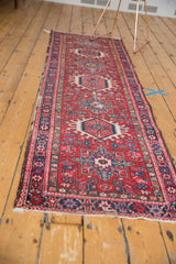 Close-up of the vintage Karaja rug runner's geometric border, rich colors, worn edge, and secured fringe.