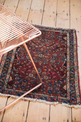Vintage Lilihan rug's raspberry red floral pattern and tattered fringe detail.