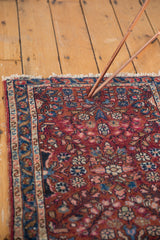Vintage Lilihan rug's floral bouquet motif on dark raspberry ground, with low pile.