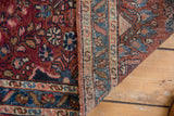 Hand-knotted Lilihan rug, low pile raspberry red floral field, and woven blue border detail.