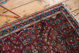 Vintage Lilihan rug corner with tattered fringe, blue border, and floral field.