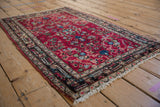 An angled view of the vintage Lilihan rug, showing its low pile and detailed floral vinery.