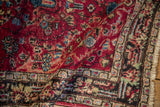 Close-up on the folded corner of a vintage Lilihan rug, showing its low pile and speckling.