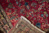 The folded corner of a vintage Persian rug reveals its low pile and hand-knotted foundation.